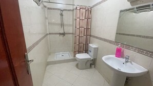 A small bathroom with a shower, toilet, and sink. - Appartement Équipé et Climatisé (Marrakech)