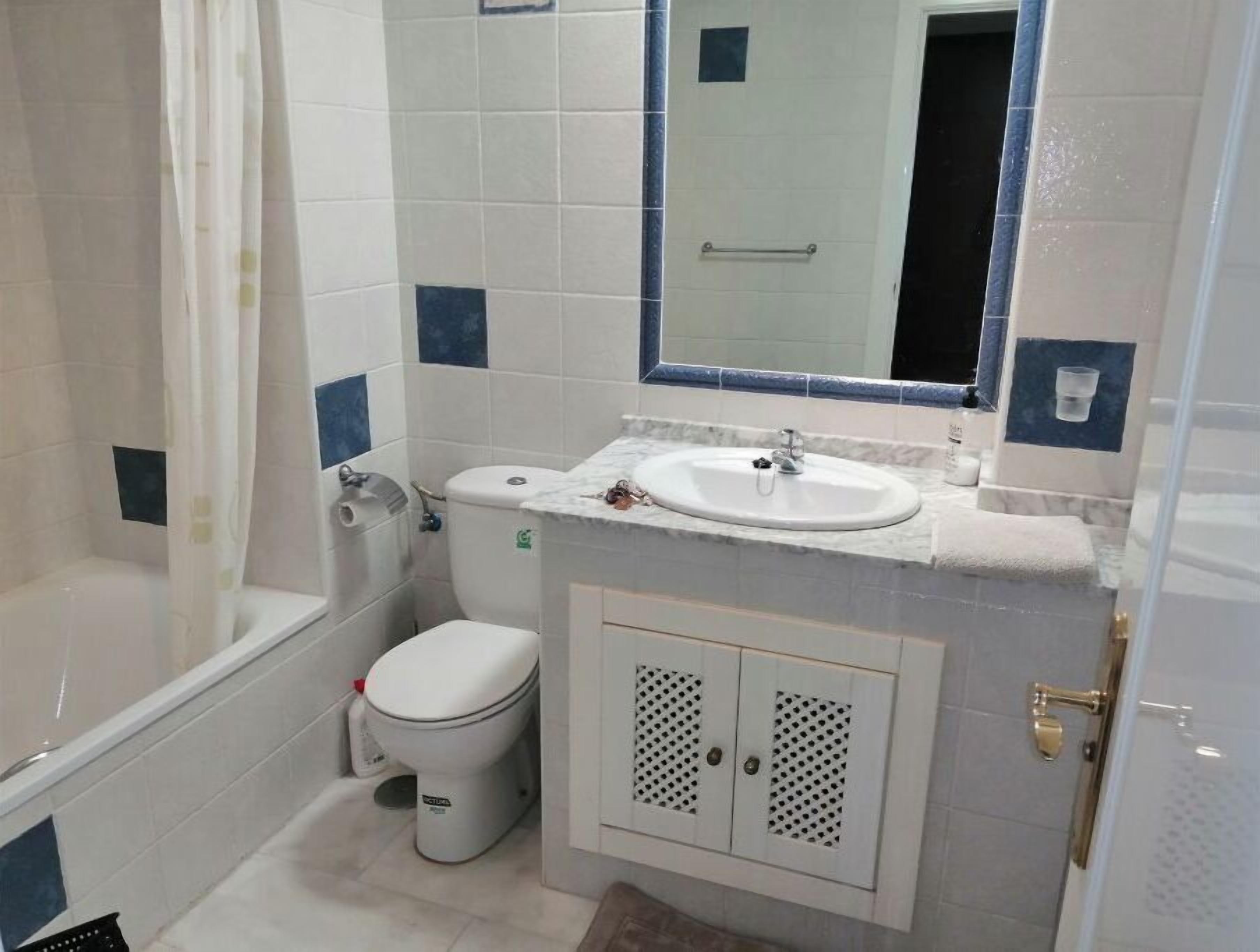 Un baño con inodoro, lavamanos y bañera.