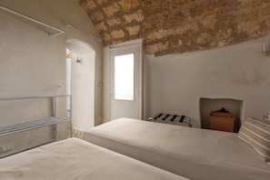 Una stanza con un letto, un tavolino e una finestra.