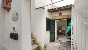 A narrow courtyard with a staircase, a small table and chairs, and a door leading to an interior space. - 3532 Borgo Vernicchia - PT by Barbarhouse (Parabita)