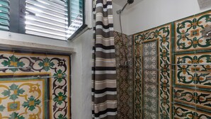 A bathroom with patterned tiles, a striped shower curtain, and a window with blinds. - 3532 Borgo Vernicchia - PT by Barbarhouse (Parabita)