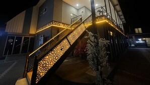Un bâtiment moderne doté d’un escalier aux motifs géométriques et éclairé d’une lumière chaleureuse.