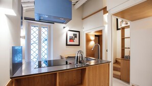 A modern kitchen with a wooden island, stainless steel appliances, and a built-in oven. - Flat Piazza del Popolo central (Roma)