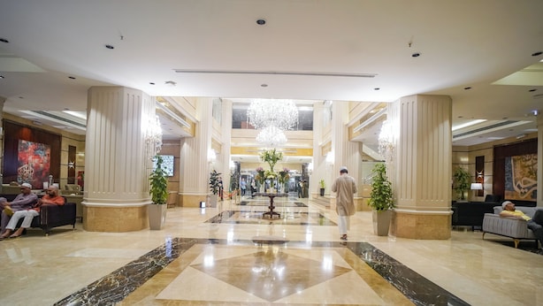A spacious lobby with marble flooring, large columns, and a chandelier. - Emaar Al Manar (Makkah)