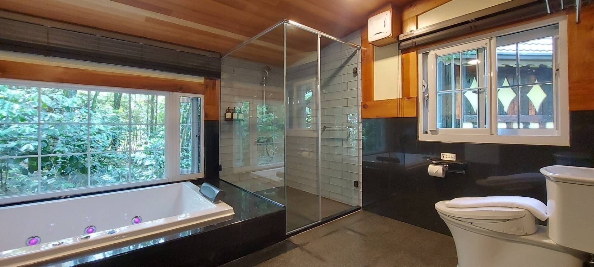 Une salle de bain avec une douche à parois de verre, une baignoire et des toilettes.