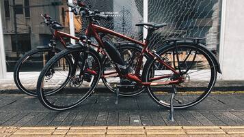 Two bicycles parked in front of a building with a large window displaying a map.