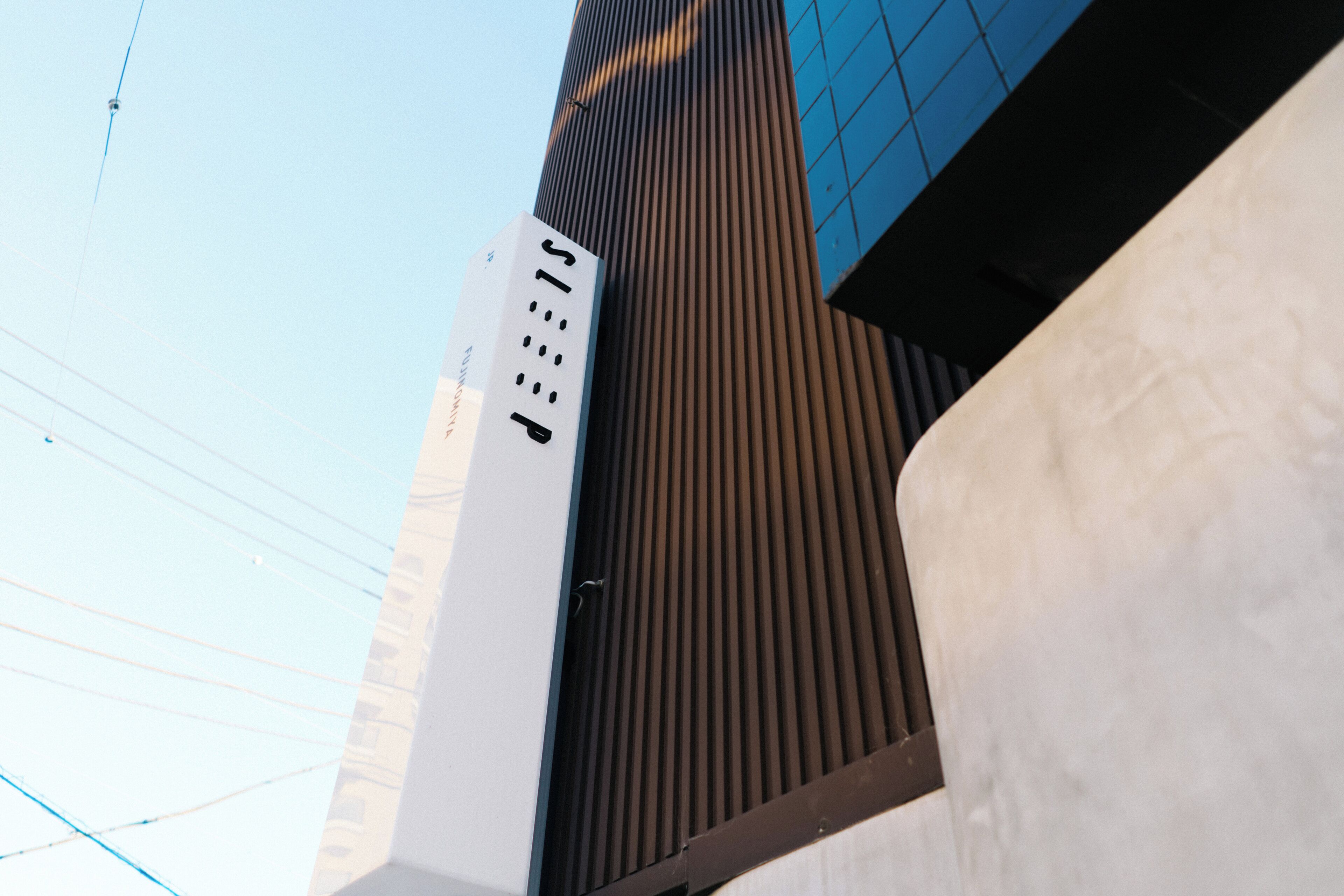 A modern building with a vertical design, featuring a mix of glass and metal elements.
