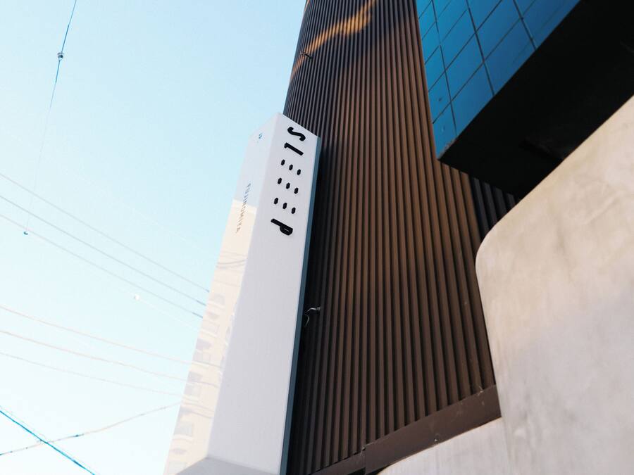 A modern building with a vertical design, featuring a mix of glass and metal elements.