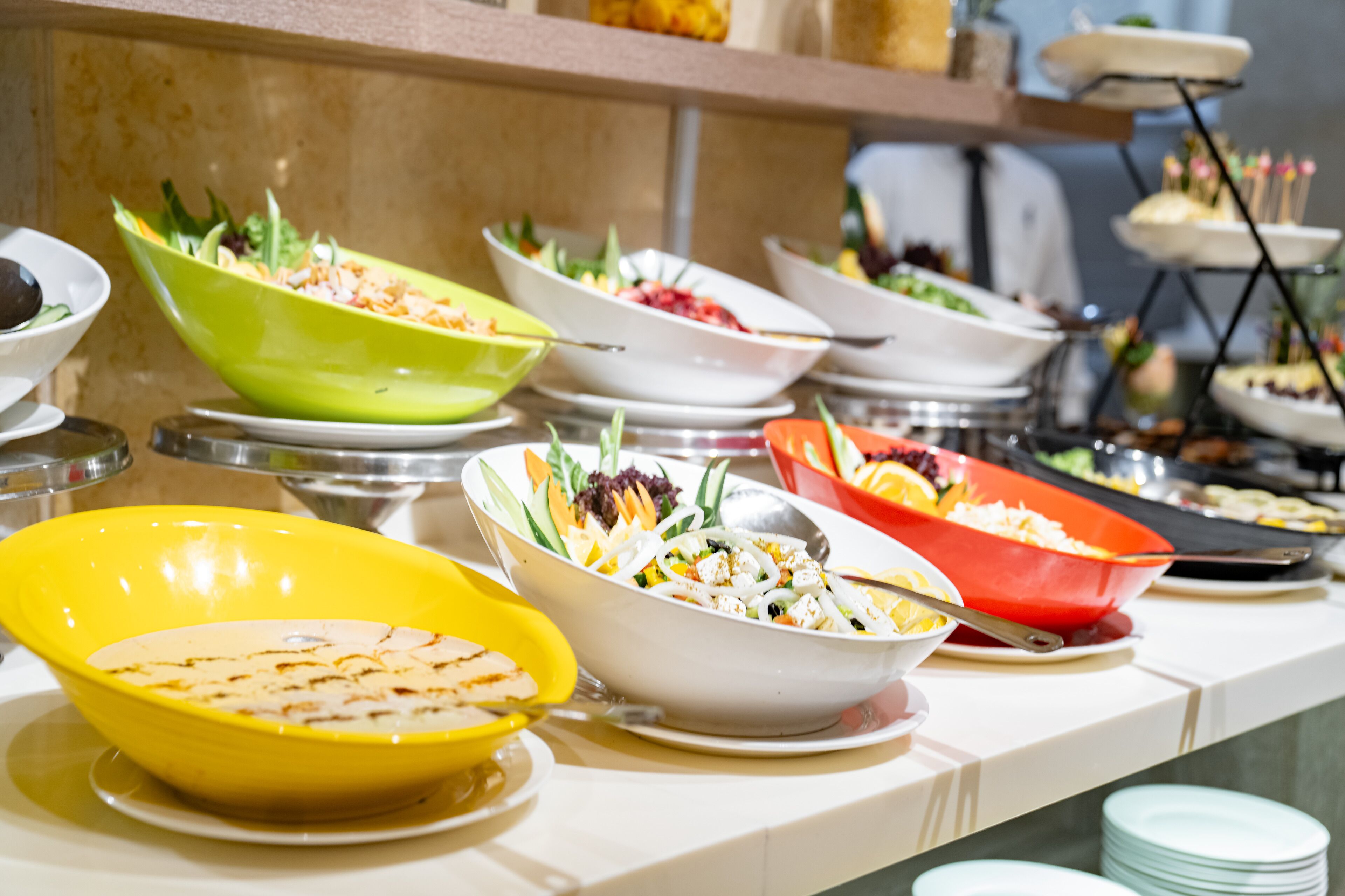A buffet table with various dishes and bowls.