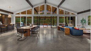 Un intérieur spacieux et moderne, doté d’un haut plafond, de grandes fenêtres et de différents espaces aménagés pour s’asseoir.