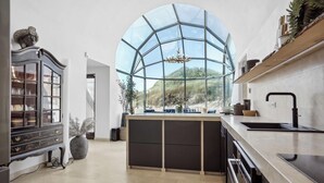A modern kitchen with a large glass window, a dark wooden cabinet, and a stainless steel countertop. - One of Denmarks Most Famous Architect Spa Houses, First Beach Line (Blokhus)