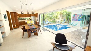 Una cocina moderna con armarios de madera y un comedor con vista a la piscina.