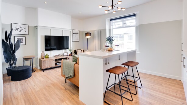 A modern kitchen with a central island, bar stools, a flat-screen TV, and a large window. - Urban Oasis by Keystone (Newport)