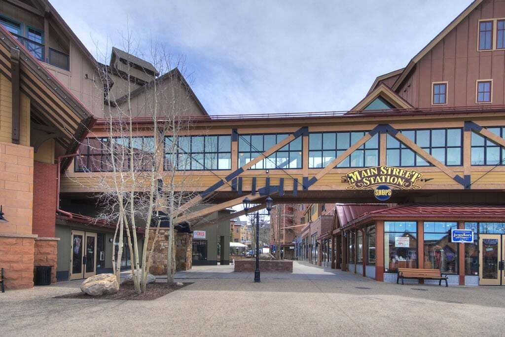 Main Street Station with a covered walkway, shops, and a stone facade building.