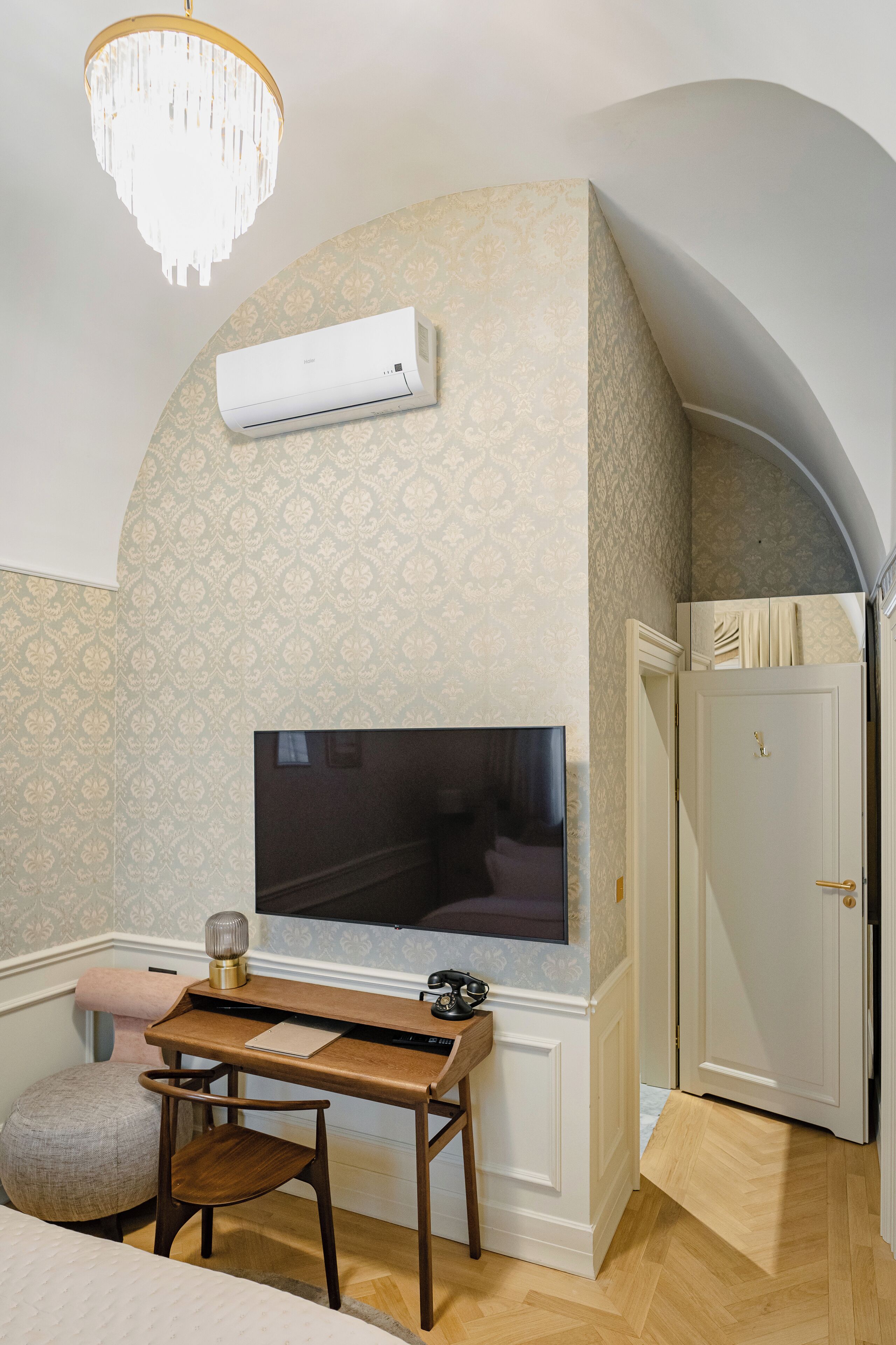 A bedroom with a TV, a desk, and a chair.