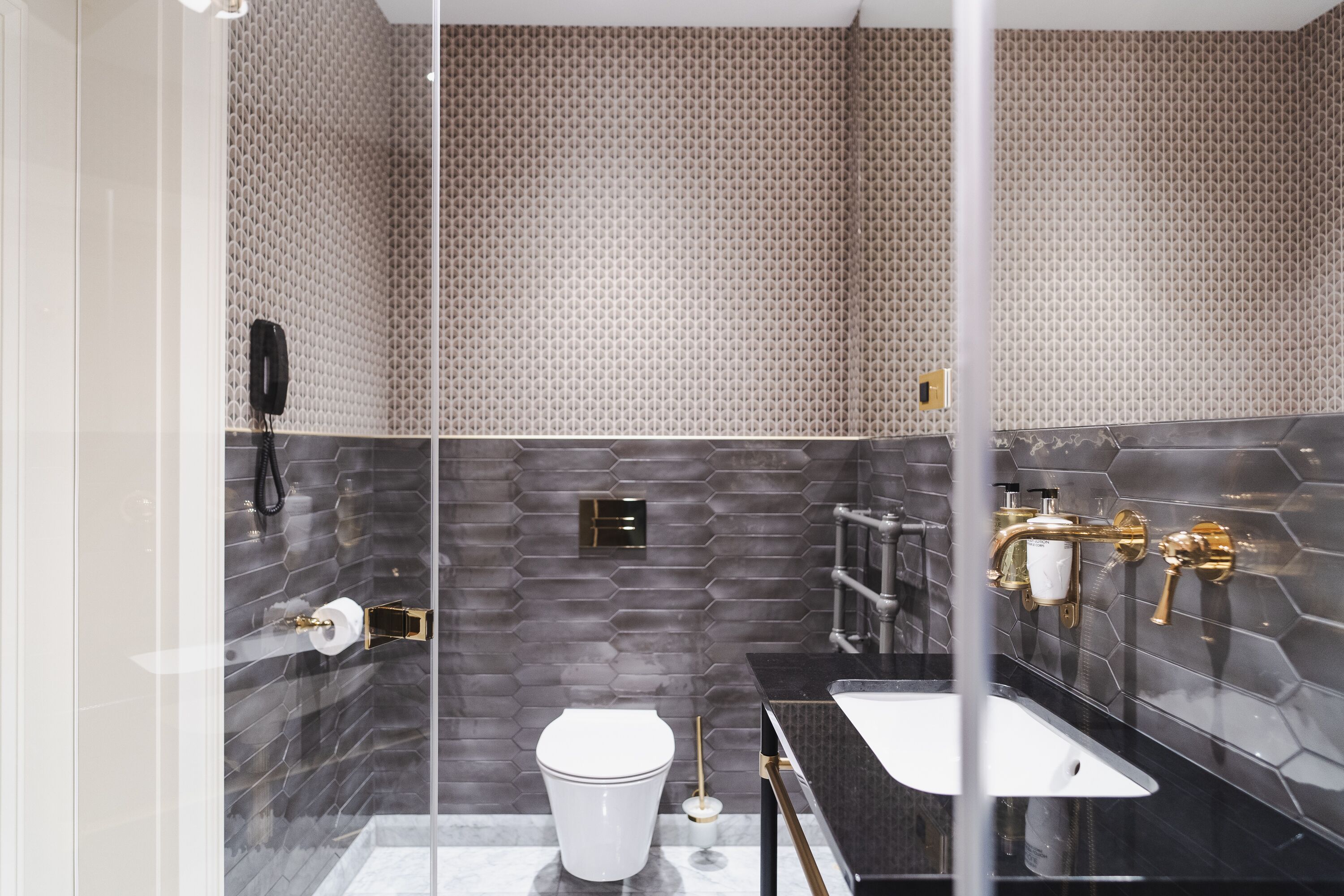 Une salle de bain moderne équipée de toilettes, d’un lavabo et d’un espace douche.