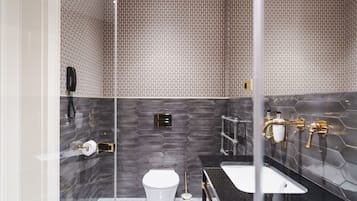 Une salle de bain moderne équipée de toilettes, d’un lavabo et d’un espace douche.