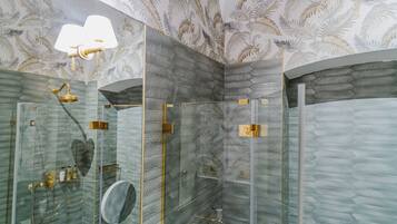 Un baño moderno con cabina de ducha de vidrio, un espejo grande y un techo con diseño.