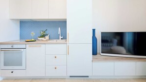 A modern kitchen with white cabinets, a built-in oven, a sink, and a large flat-screen TV. - Hedera Estate, Hedera Studio 1 (Dubrovnik)