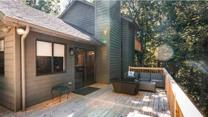 A deck with outdoor furniture, a door, and a window.