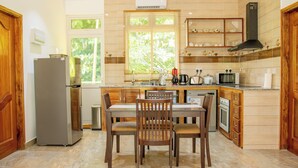 Una cocina con una mesa de comedor, sillas, un refrigerador, un microondas y un lavavajillas.