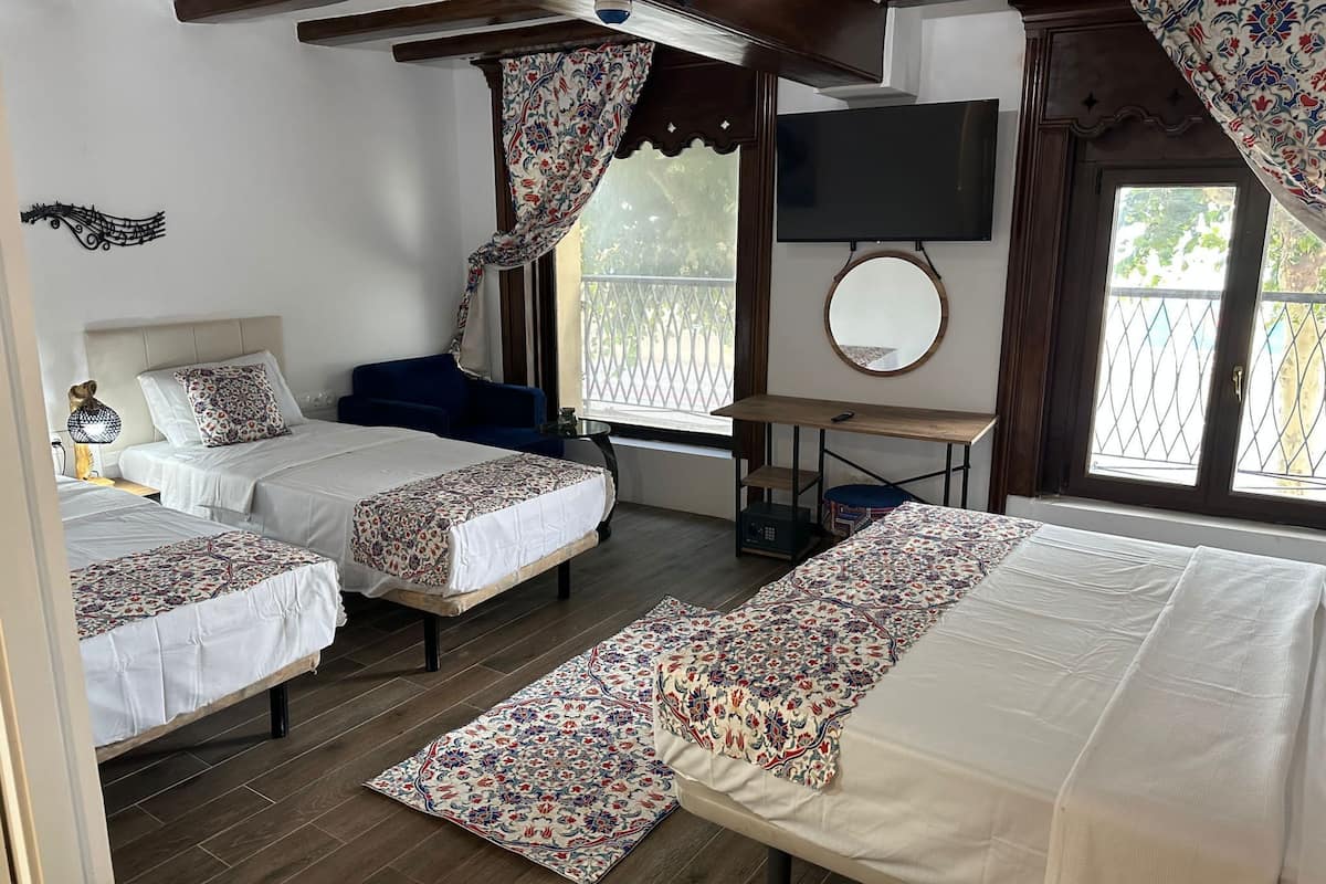 Deluxe vierpersoonskamer | Luxe beddengoed, donsdekens, een kluis op de kamer, een bureau