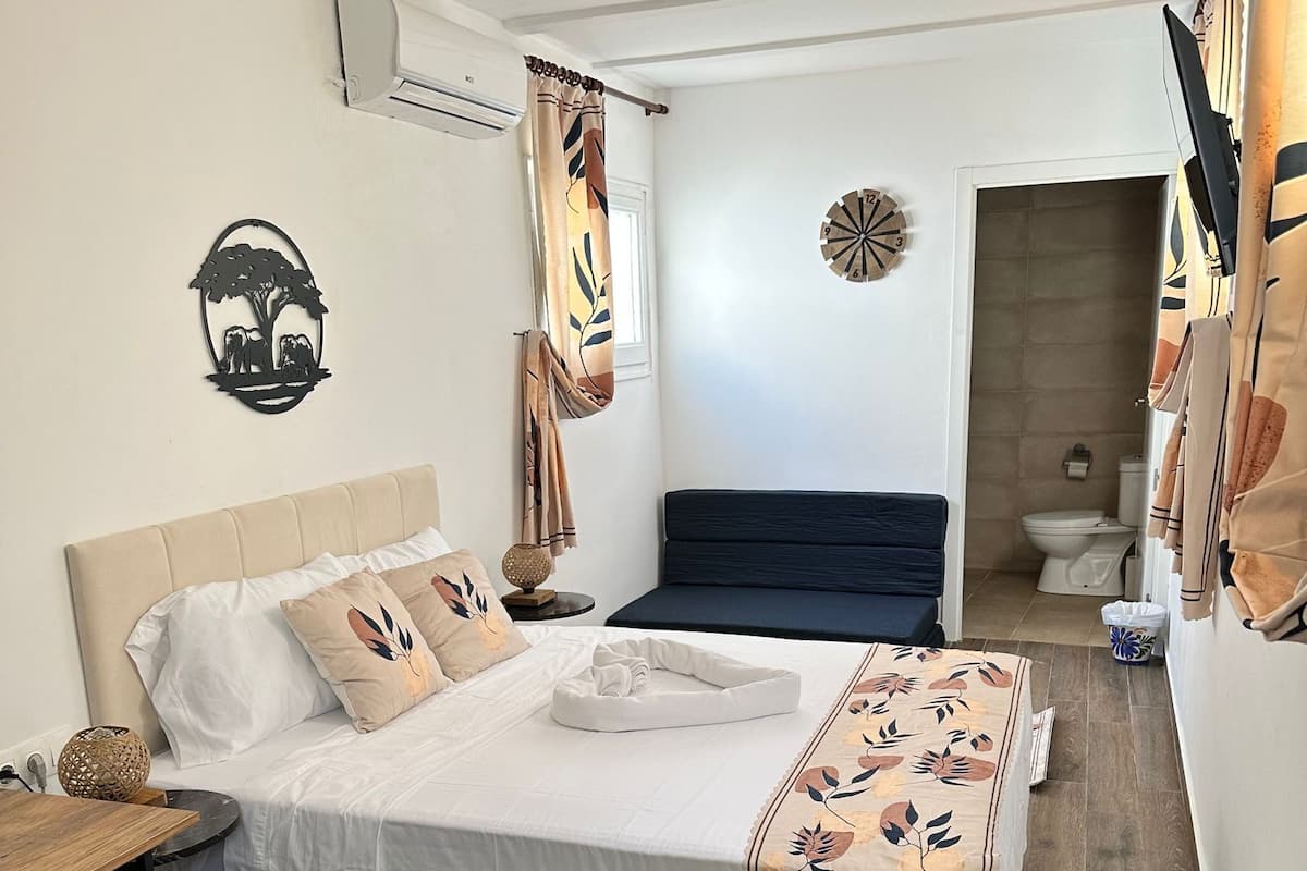 Deluxe driepersoonskamer | Luxe beddengoed, donsdekens, een kluis op de kamer, een bureau