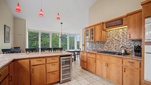 Una cocina moderna con armarios de madera, una isla integrada y un salpicadero de piedra.