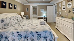 Une chambre à coucher avec un lit, une commode et un ventilateur de plafond.