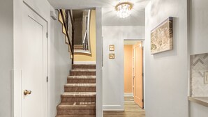 Eine Treppe mit Holzvertäfelung, eine Deckenleuchte und ein gerahmtes Bild an der Wand.