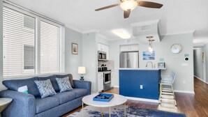 A modern living room with a gray sofa, a round coffee table, and a blue accent wall.