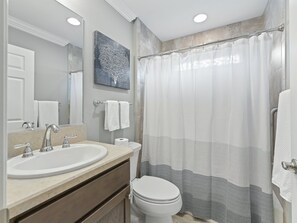 A bathroom with a sink, mirror, toilet, and shower curtain. - Stay in Style near the Golf Course in the Village of Fenney! (The Villages)