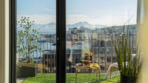 A balcony with a view of a harbor, mountains, and a cityscape. - TotalApartments Vervet Gjøa (Tromsø)