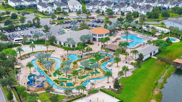 Vista aérea de um resort com várias piscinas, quadra de tênis e campo de golfe.