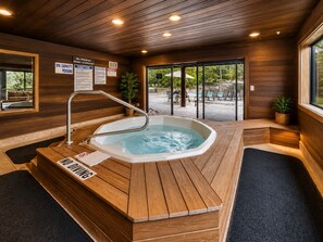 A spa area with a hot tub, wooden flooring, and a view of the outdoor pool area. - Hidden Haven At Apache Trail! 4 Bedroom Townhouse by RedAwning (Park City)