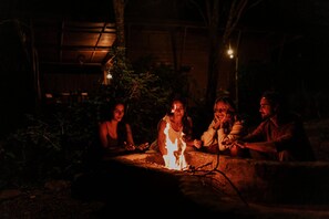 A group of people gathered around a campfire at night. - Bangalô Ametista (Alto Paraíso de Goiás)