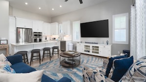 A modern living room with a sofa, a coffee table, and a TV. - 134 Pearl St 3 Bedroom Home by RedAwning (Fort Myers Beach)