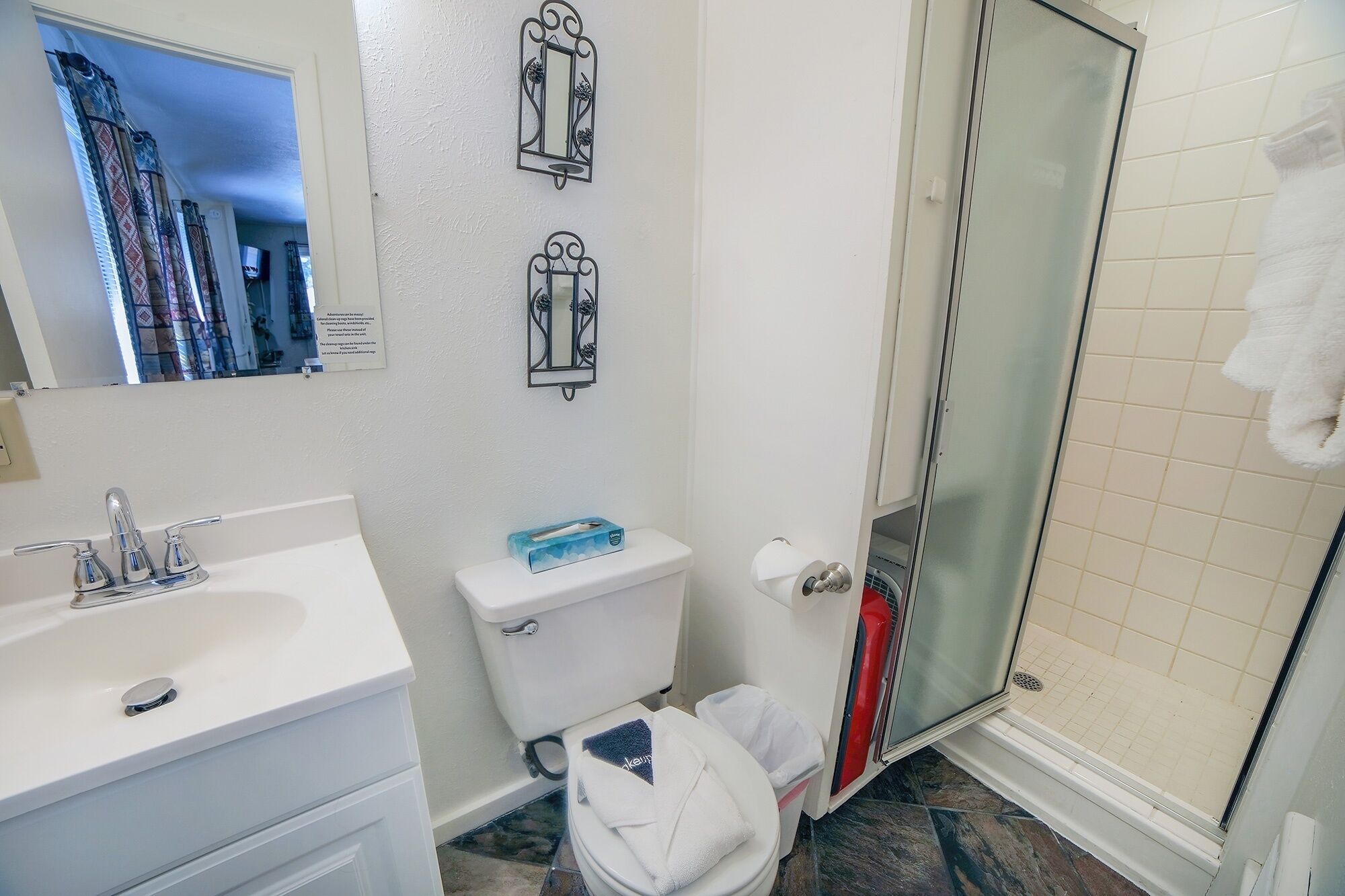 A bathroom with a white sink, a toilet, and a shower.