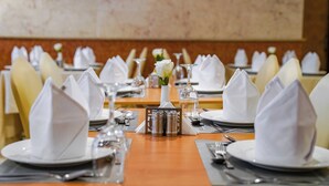 Un restaurante con mesas ordenadas, servilletas blancas y saleros de plata.