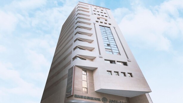 Un edificio alto y moderno con una entrada destacada y señalización para "EMARALINHA HOTEL".