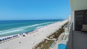 A beach view from a balcony with a pool and lounge chairs. - SURROUNDING VIEWS OF GULF!! BEAUTIFUL 2/2 AVAILABLE NOW!! (Panama City)