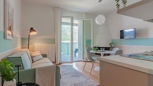 A modern apartment with a living area, dining space, and kitchenette. - Ninfea Apartments by Wonderful Italy - Teal (Lezzeno)