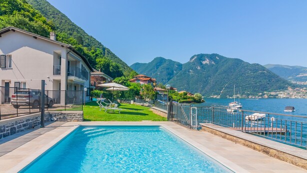 Piscina com vista para o mar e montanhas.