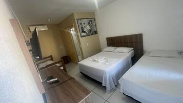 Een hotelkamer met twee bedden, een bureau en een televisie.