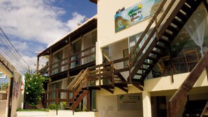 A building with a staircase, a signboard, and a vehicle parked in the background. - Pousada Brisa da Canoa (Aracati)