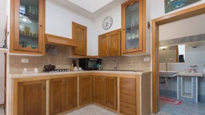 A kitchen with wooden cabinets, a microwave, and a stove. - 3342 Casa di Enza by Barbarhouse (Ugento)
