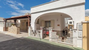A white building with a stone facade, an arched entrance, and a gated driveway. - 3342 Casa di Enza by Barbarhouse (Ugento)
