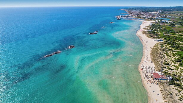 An aerial view of a coastal area with a beach, clear blue waters, and a small town in the background. - 3342 Casa di Enza by Barbarhouse (Ugento)