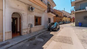A narrow street with parked cars and buildings with balconies. - 3459 Casetta Mulino by Barbarhouse (Nardò)
