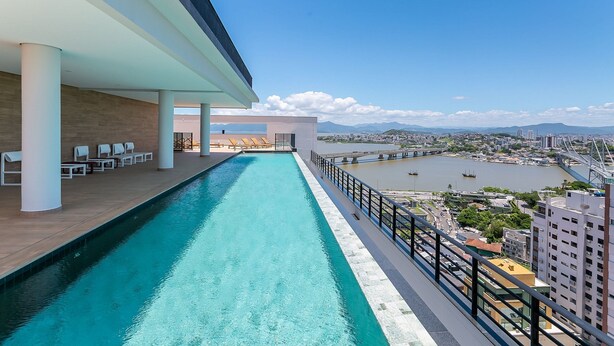 A rooftop pool with a view of a cityscape and a river. - WI-FI 500MB | Sea View Studio with Foodhall #CA47 (Florianópolis)